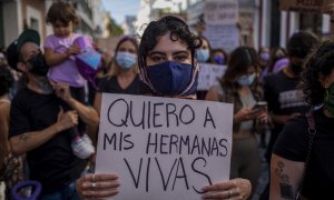 Mujer con pancarta "quiero vivas a mis hermanas". Foto de archivo.