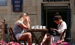 Dos mujeres en la terraza de un restaurante de la Rua da Raiña, el día en que el TSXG declara nula la petición de certificado Covid para entrar en hostelería, a 12 de agosto de 2021, en Santiago de Compostela, A Coruña, Galicia