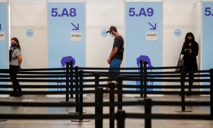 Varias personas esperan su turno para recibir una dosis de la vacuna contra la covid en Barcelona.