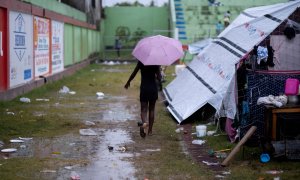 Una mujer camina en un campamento improvisado en Les Cayes, tras el  terremoto del pasado fin de semana en Haití. REUTERS / Ricardo Arduengo