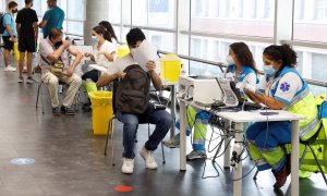 Varias personas reciben la vacuna contra la covid en el punto de vacunación masivo instalado en el Wizink Center de Madrid.