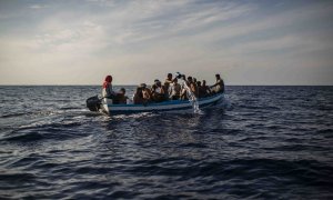 Un grupo de 17 jóvenes tunecinos achican agua de la patera en la que navegan hacia Lampedusa (Italia) escoltadas por el buque Astral de Open Arms, este miércoles.