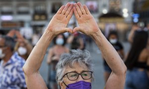 Una mujer levanta las manos en una concentración para exigir “El Pacto de Estado Contra la Violencia de Género”, a 6 de agosto de 2021, en la Puerta del Sol.