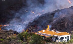 Una imagen tomada por un dron de la colada de lava del volcán de La Palma, a punto de arrasar con una casa, este 24 de septiembre de 2021.