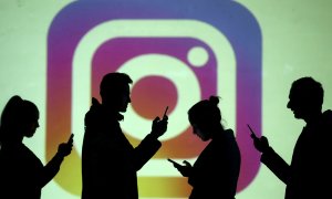 Varias siluetas de personas con su móvil, delante de un logo de la red social Instagram, propiedad de Facebook. REUTERS/Dado Ruvic/Illustration