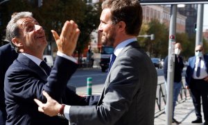 El líder del PP, Pablo Casado (dcha), saluda al expresidente francés Nicolás Sarkozy, tras participar en la mesa sobre "La sociedad abierta y sus enemigos" en la tercera jornada de la convención nacional del Partido Popular, este miércoles en Madrid. E