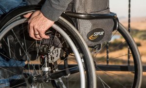 Fotografía detalle de una persona en silla de ruedas.