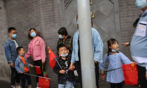 05/10/2021 Los niños sostienen banderas chinas cerca de la Ciudad Prohibida durante las vacaciones del Día Nacional tras un brote de la enfermedad por coronavirus