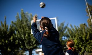 Una niña juega a baloncesto en el patio de un colegio en Madrid.