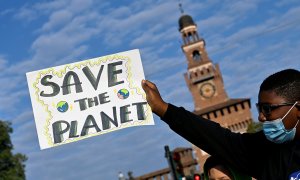 Un joven activista de Fridays For Future muestra una pancarta con el lema "Salvemos el planeta" en Milán, en una protesta previa a la COP26 de Glasgow.
