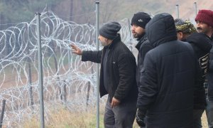 Migrantes que se acercan a una valla reforzada con alambre de púas cerca de su campamento en la frontera entre Bielorrusia y Polonia en la región de Grodno, Bielorrusia, el 10 de noviembre de 2021 .