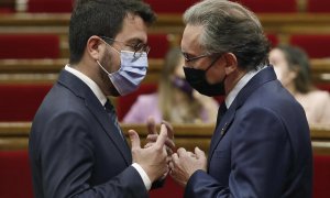 El president, Pere Aragonès, habla con el conseller d'Economia, Jaume Giró, durante la sesión de control en el Parlament.