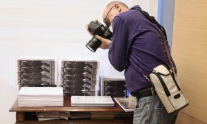 Un fotoperiodista realiza una fotografía a varios tomos de las enmiendas presentadas a los Presupuestos del Estado para 2022, en la Comisión de Presupuestos. E.P./Eduardo Parra