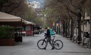 Un trabajador de Deliveroo en bicicleta por una calle de Barcelona.