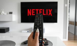 Mando de televisión apuntando a una pantalla donde aparece el logo de Netflix.