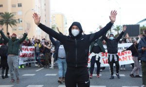 Manifestantes con las manos alzadas ante la policía que han intervenido durante los disturbios producidos por los estudiantes que se han manifestado en apoyo al sector del metal a 23 de noviembre 2021 en Cádiz (Andalucía)