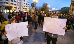Dos personas sostienen pancartas donde se lee "Burgos existe", en una manifestación para reclamar comunicaciones por tren y por carretera para Burgos, a 20 de noviembre de 2021, en Burgos, Castilla y León.