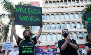 Un mujer con un cartel en el que se lee: Violencia vicaria, participa en una concentración feminista en Tenerife.