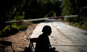 24/12/2021 Un soldado tailandés se sienta frente a una carretera bloqueada que conduce a la frontera entre Tailandia y Myanmar, donde aún continúan los combates