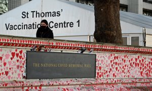 Una persona fuera del hospital St.Thomas con el National Memorial Wall en primer plano en Londres