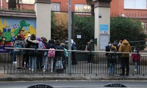 Pla general de l'Escola de les Aigües, amb pares i mares esperant alumnes.