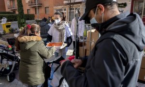 Un voluntario de la Fundación Madrina, entrega alimentos a personas vulnerables.