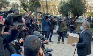 Carlos San Juan con su caja de firmas en el exterior del Ministerio de Economía, y rodeado de periodistas.