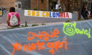 Una pancarta contra el presidente de Colombia, Iván Duque, durante su visita a España, en la plaza Arturo Barea de Lavapiés a 16 de septiembre de 2021, en Madrid