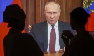 Varias personas ven en Moscú el discurso televisado del presidente ruso Vladimir Putin en el que justifica su ataque a Ucrania este jueves.