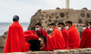 24/02/2022. Migrantes descansan en una zona cercana a los Jameos del Agua en la isla de Lanzarote tras ser rescatada su patera.