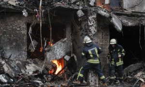 Los bomberos extinguen un incendio en un bloque de viviendas afectado por un bombardeo nocturno en una zona residencial de Kiev, Ucrania.