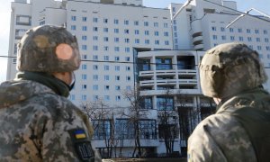 Los militares ucranianos miran un edificio residencial dañado, después de que Rusia lanzó una operación militar masiva contra Ucrania, en Kiev, Ucrania, el 26 de febrero.
