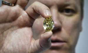 El subdirector de ventas de diamantes de Alrosa, Yevgeny Tsybukov, muestra un elegante diamante ovalado de color amarillo verdoso parduzco, en Moscú el 3 de julio de 2019.