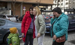 Svetlana (derecha) y su hija Julia (izquierda) son recogidas por su prima Viktoria tras llegar en autobús desde Polonia, a donde huyeron de los combates en Irpin, junto a Kiev, Ucrania, este martes.