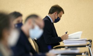 El presidente de la Xunta, Alberto Núñez Feijóo, sentado entre los periodistas durante la intervención del conselleiro de Economía, Miguel Corgos, durante la rueda de prensa posterior al Consello de la Xunta, en Santiago de Compostela. EFE/Lavandeira jr