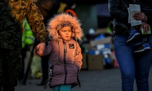 11/03/2022 Un militar ayuda a una niña después de que atravesara con su familia la frontera ucraniana con Polonia por Medyka