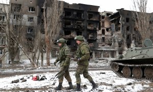 Los miembros del servicio de las tropas prorrusas caminan cerca de un edificio residencial que resultó gravemente dañado durante el conflicto entre Ucrania y Rusia en Volnovakha.