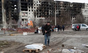 Un hombre recoge sus pertenencias cerca de un bloque de pisos destruido destruido tras un bombardeo en Mariupol.