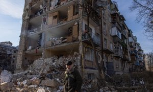 Un hombre camina este viernes por delante de un edificio residencial dañado por un bombardeo en el distrito de Podilskyi en Kiev, Ucrania.