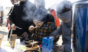 Varios niños se alimentan este lunes en el campamento de refugiados en Budomierz (Polonia), en el paso fronterizo con Ucrania más cercano al bombardeo del IPSC de Yavoriv, a 25 kilómetros de la frontera polaca.