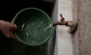 Detalle de la mano de una persona sacando agua del grifo.