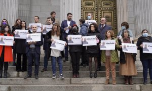 Varios diputados posan a las puertas del Congreso de los Diputados con carteles con fotos de Pablo González y la etiqueta #FreePablo este 30 de marzo de 2022.