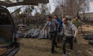 07/04/2022 Un grupo de voluntarios cargan en una furgoneta en el cementerio los cuerpos sin vida de los asesinados en Bucha