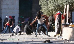 Los palestinos se enfrentan con la policía israelí dentro del complejo de la mezquita de Al-Aqsa después de que la policía israelí ingresara al complejo antes del amanecer mientras miles de musulmanes se reunían para rezar durante el mes sagrado del Ramad