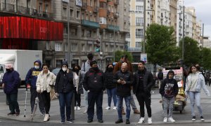 (20/4/2022) Varias personas esperan en un semáforo de la Gran Vía de Madrid el pasado miércoles, primer día sin la obligación de llevar mascarillas en interiores.