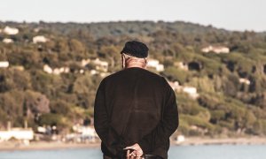 Un hombre mayor observa el mar.