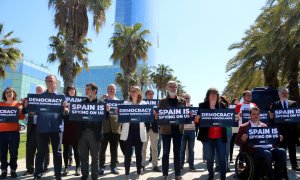 Diversos independentistes espiats per Pegasus en el 'Catalangate' mostren cartells contra l'espionatge davant de l'hotel Vela de Barcelona.