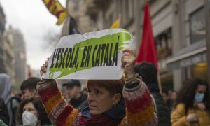 Una manifestante con una pancarta que reza 'L'escola, en catalá', en una huelga por la sentencia del 25% en castellano en la educación catalana, a 23 de marzo de 2022, en Barcelona.