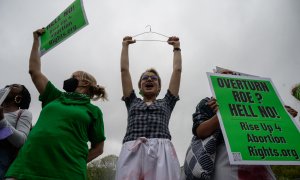 Un manifestante sostiene una percha, un símbolo del movimiento por los derechos reproductivos, mientras los activistas organizan una protesta de "muerte" en el parque Washington Square en Nueva York el 13 de mayo de 2022.