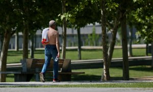 19/5/22-Un hombre camina sin camiseta el día en que España ha comenzado a sufrir un "importante" episodio cálido con temperaturas de pleno verano, a 17 de mayo de 2022, en Madrid (España).